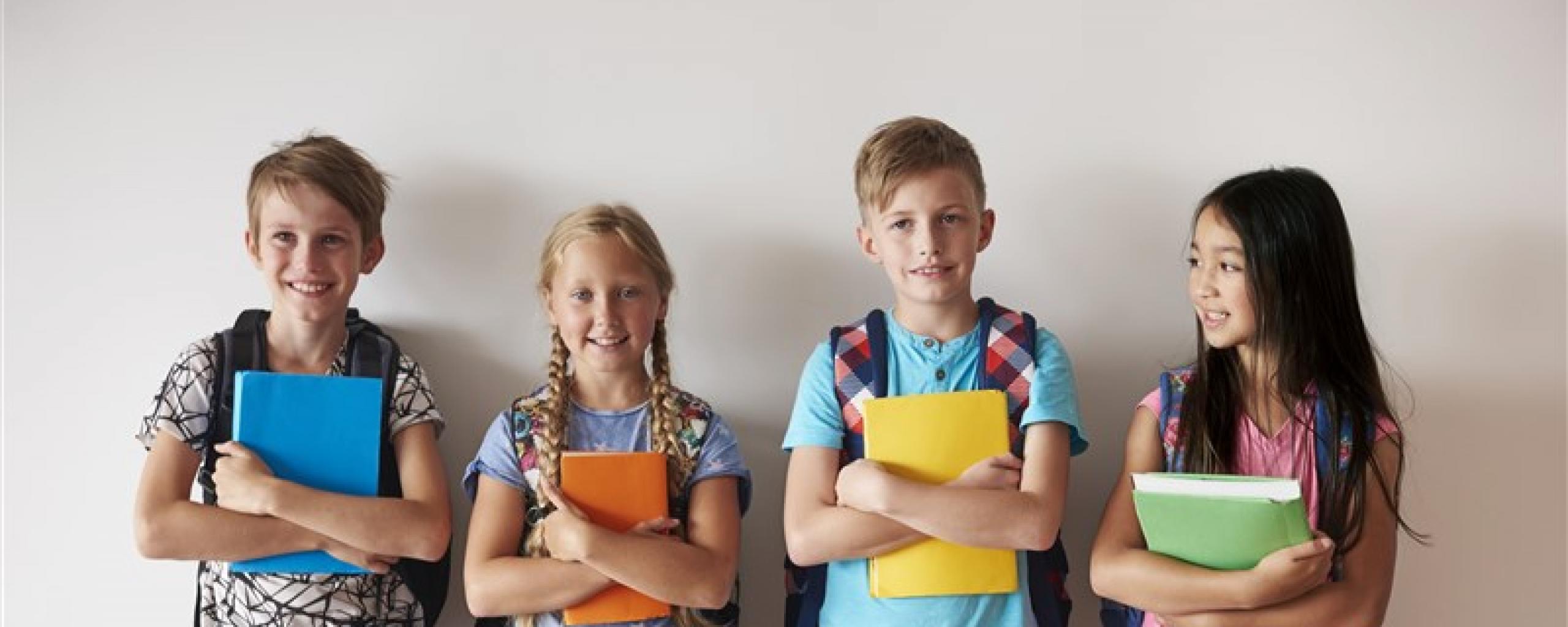 Kinderen met schoolspullen in de hand